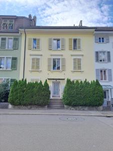 una casa amarilla con escaleras delante en Casa Maria Apartments, en Solothurn