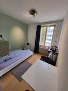 a bedroom with a bed and a table and a window at Casa Maria Apartments in Solothurn
