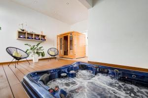 a jacuzzi tub in a room with two chairs at Villa Goa - By Luxury Villas Malta in Mellieħa