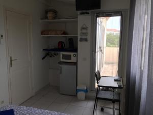 een kleine keuken met een fornuis en een raam bij Chambre coquette dans villa proche de la plage in Sète
