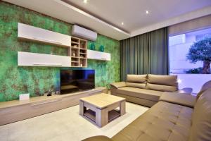 a living room with a couch and a tv at Villa Goa - By Luxury Villas Malta in Mellieħa
