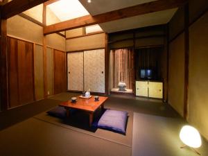 a room with a wooden table and a room with a window at sakainoma hotel 熊 in Sakai