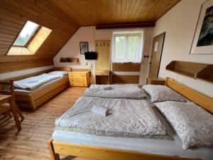 a bedroom with two beds in a wooden house at Churáňov Lanovka in Stachy