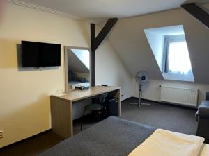 een slaapkamer met een bed en een bureau met een televisie bij Hotel U Dvou medvídků in Chomutov