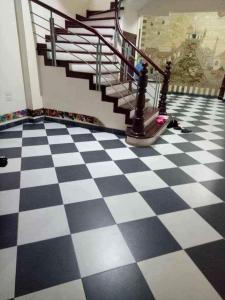 a black and white checkered floor with a staircase at 3BT home in Hanoi