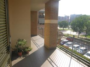 einen Balkon eines Gebäudes mit Pflanzen und einem Parkplatz in der Unterkunft Appartamento signorile in Orbassano