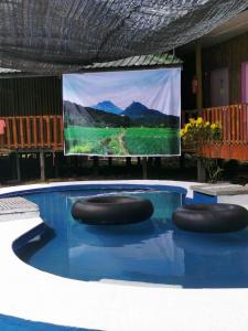 Kota Belud的住宿－Tambatuon Homestead，游泳池,在屏幕前设有两个凳子
