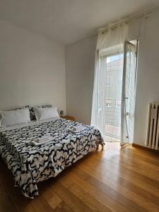 a bedroom with a bed and a large window at Alloggio Desiri in Pavia