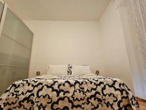 een slaapkamer met een bed met een zwart-wit dekbed bij Alloggio Desiri in Pavia