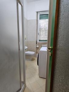 een badkamer met een toilet en een raam en een deur bij Alloggio Desiri in Pavia