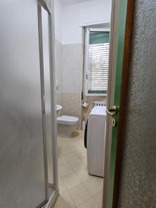 a bathroom with a toilet and a window and a door at Alloggio Desiri in Pavia