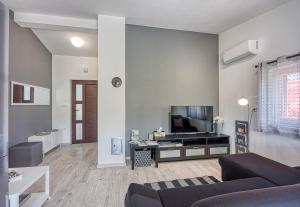 uma sala de estar com um sofá e uma televisão de ecrã plano em Family Friendly House Kacana - Happy Rentals em Vodnjan