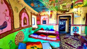 a bedroom with a bed in a room with a painted wall at Hotel Lotus Haveli in Jaisalmer