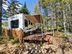 an rv with a wooden deck in the woods at Ranch vdv in Thetford Mines