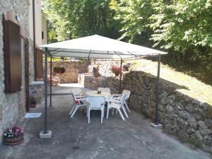 a table and chairs under a white umbrella at Le Pietre Ricce B&B in Roccamontepiano