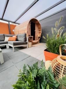 an outdoor patio with a tent and chairs and plants at Charley's Wellness Suite in Westkapelle