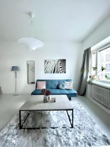 a living room with a blue couch and a table at Stylish Studio at the Heart of Helsinki in Helsinki