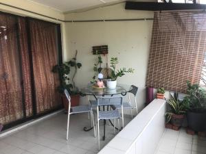 a table and chairs on a balcony with plants at David beachside apartment in Port Dickson