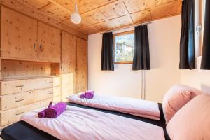 Dos camas en una habitación con paredes de madera. en Chasa Muglin Ardez, en Ardez