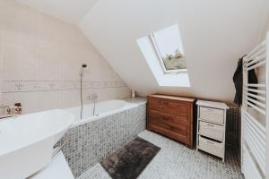a bathroom with a bath tub and a sink and a window at Cabin Sonka in Oščadnica