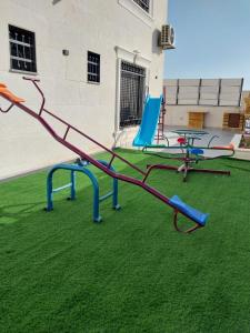 um parque infantil com escorrega e cadeiras na relva em Sea view chalet em Taba