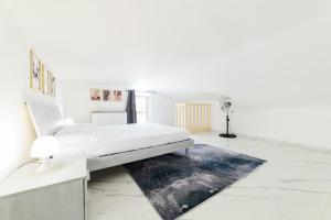 a white bedroom with a bed and a rug at Casa Alexander in Nocera Inferiore