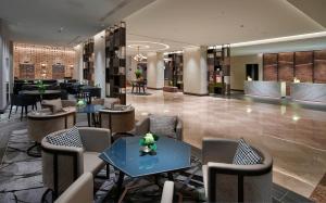 un vestíbulo de un hotel con mesas y sillas en Hilton Milan en Milán