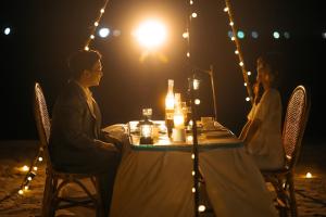 a man and a woman sitting at a table at night at Bintan Exotica Resort By WH - Free Breakfast in Berakit +74 photos