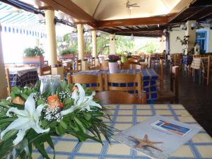 a table with white flowers on a table in a restaurant at Votsalakia Hotel in Marathokampos