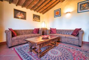 Sala de estar con 2 sofás y mesa de centro en Agriturismo Galgani - Historical Medieval House with Exclusive Pool and Park, en Chiusdino