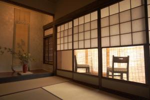a room with two chairs and a window at Aioi Yanto 一日一組限定古民家宿 in Otaru