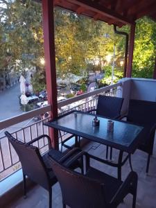 einen Tisch und Stühle auf einem Balkon mit Aussicht in der Unterkunft Ξενωνας Κάρμα in Orma