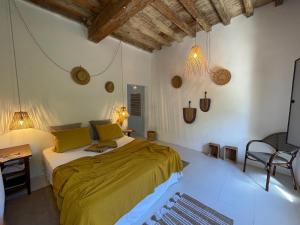 sypialnia z łóżkiem z żółtą pościelą i biurkiem w obiekcie Maison Tara verte au Mas Montredon w mieście Arles