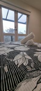 una camera da letto con finestra e letto zebrato; di Treetop Leura Deluxe Family Cabin a Leura