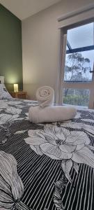 a bedroom with a bed with a flower pattern on it at Treetop Leura Deluxe Family Cabin in Leura