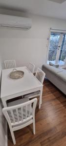 a white table and chairs in a room with a couch at Treetop Leura Deluxe Family Cabin in Leura