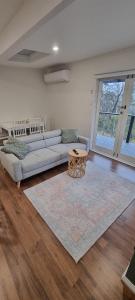a living room with a couch and a table at Treetop Leura Deluxe Family Cabin in Leura
