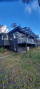 una casa azul con muchas ventanas en Treetop Leura Deluxe Family Cabin, en Leura