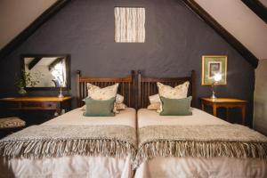 una camera con due letti con cuscini di Cypress Cottage Guest House a Swellendam