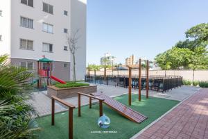 a playground with a slide and a swing set at Aptos em Bal Piçarras a150m da PRAIA, dois quartos, sala de estar, COZINHA COMPLETA, SACADA com CHURRASQUEIRA, WI-FI, PISCINA, PORTARIA 24h, PLAYGROUND e QUADRA DE ESPORTES in Piçarras