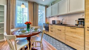 a kitchen with a table and chairs in a kitchen at Apartament Górska 5 by Royal Aparts in Świeradów-Zdrój