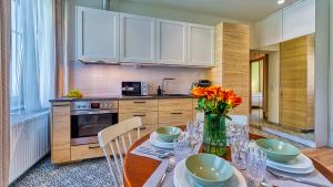 a kitchen with a table with a vase of flowers on it at Apartament Górska 5 by Royal Aparts in Świeradów-Zdrój