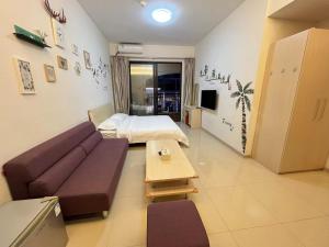 uma sala de estar com um sofá e uma cama em Seaman Light Luxury Apartment em Zhongshan