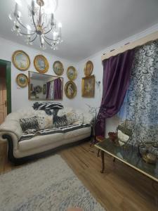 uma sala de estar com um sofá e pratos na parede em Vikendica Nada em Ljubovija