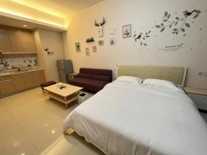 um quarto com uma cama grande e uma cozinha em Seaman Light Luxury Apartment em Zhongshan