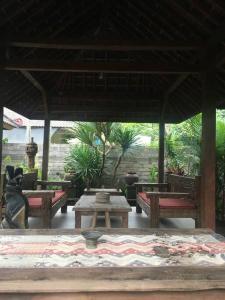 - un pavillon avec des bancs et des tables sur une terrasse dans l'établissement Din House Jembrana, à Negara