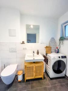 een badkamer met een wastafel en een wasmachine bij theSunset Club - STUDIO Küche - Balkon - Parken in Memmingen