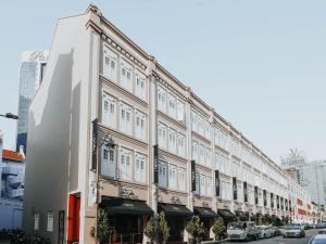 a large building with white windows on a street at Hotel 1900 Chinatown in Singapore