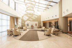 a large lobby with chairs and a chandelier at Savitsky Plaza in Samarkand