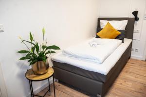 Un dormitorio con una cama con una planta. en Hotel Kavala en Lohmar